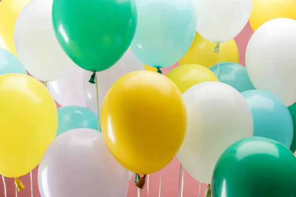 Vista de cerca de globos decorativos multicolores sobre fondo rosa - foto de stock