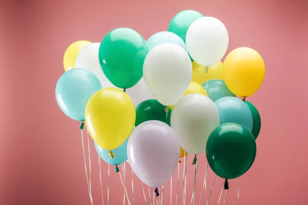 Bright green, yellow, white and blue decorative balloons on pink background — Stock Photo