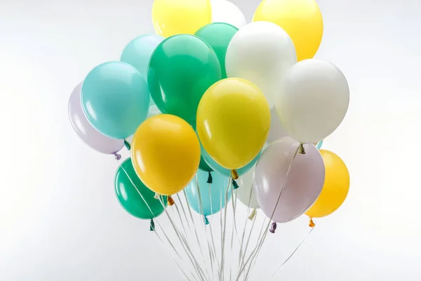 Globos decorativos de color verde brillante, amarillo y azul sobre fondo blanco - foto de stock