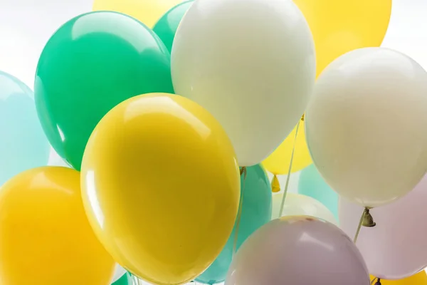 Vista de cerca de globos decorativos de color verde brillante, amarillo y azul - foto de stock