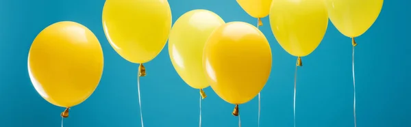 Partido brillante globos amarillos sobre fondo azul, tiro panorámico - foto de stock