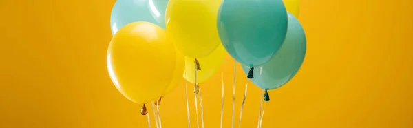 Balões azuis e amarelos decorativos festivos em fundo amarelo, tiro panorâmico — Fotografia de Stock
