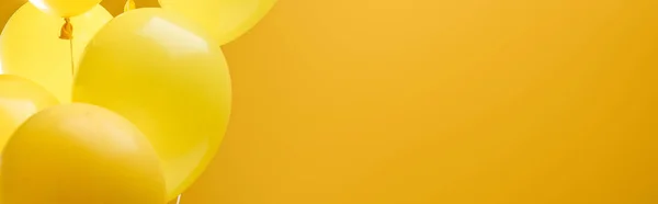 Colorful minimalistic decorative balloons on yellow background, panoramic shot — Stock Photo