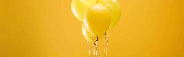 Ballons décoratifs minimalistes festifs sur fond jaune, plan panoramique — Photo de stock