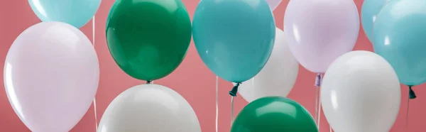 Ballons décoratifs de fête vert vif, blanc et bleu sur fond rose, plan panoramique — Photo de stock