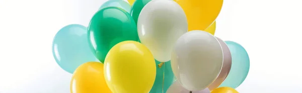 Ballons décoratifs verts, jaunes et bleus sur fond blanc, plan panoramique — Photo de stock