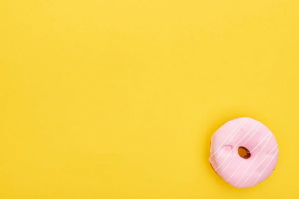 Вид зверху смачний рожевий засклений пончик на яскраво-жовтому фоні — стокове фото