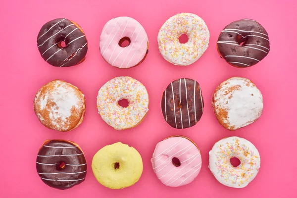 Vista superior de saborosos donuts envidraçados no fundo rosa — Fotografia de Stock