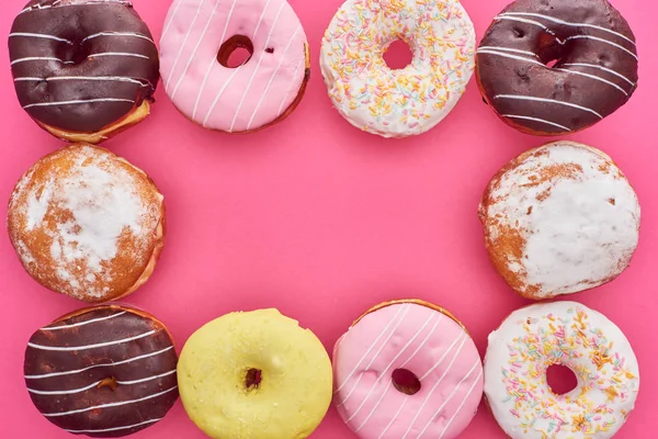 Quadro de saborosos donuts envidraçados no fundo rosa brilhante — Fotografia de Stock