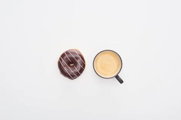 Vista superior de la sabrosa rosquilla de chocolate glaseado y la taza de café sobre fondo blanco - foto de stock