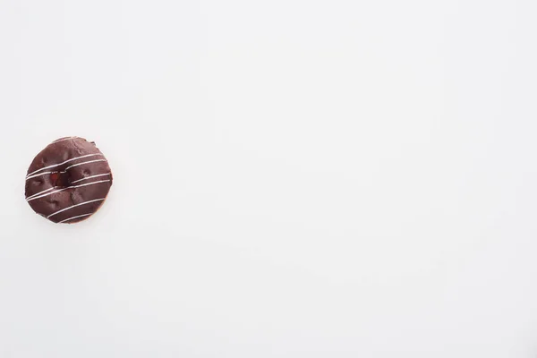 Vista superior do saboroso donut de chocolate vidrado no fundo branco com espaço de cópia — Fotografia de Stock