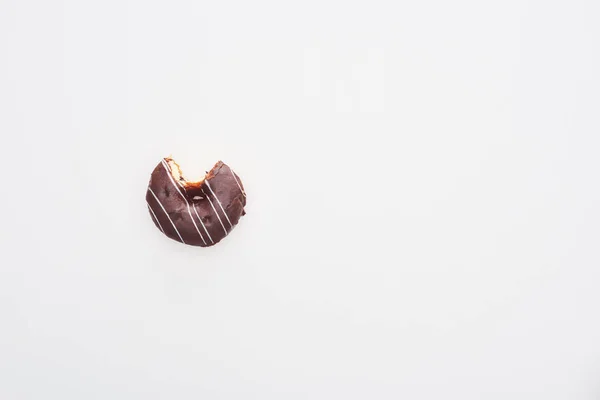 Draufsicht auf gebissene glasierte Schokolade Donut auf weißem Hintergrund mit Kopierraum — Stockfoto