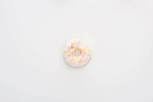 Vista superior do donut branco mordido com polvilhas no fundo branco — Fotografia de Stock