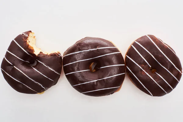 Top view of chocolate tasty glazed doughnuts on white background — Stock Photo