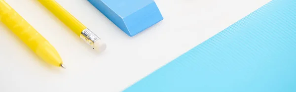 Panoramic shot of blue eraser, folder, yellow pen and pencil — Stock Photo