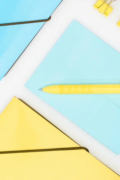 Papelaria amarela e azul com pastas, caneta, envelope e clipes de papel isolados em branco — Fotografia de Stock