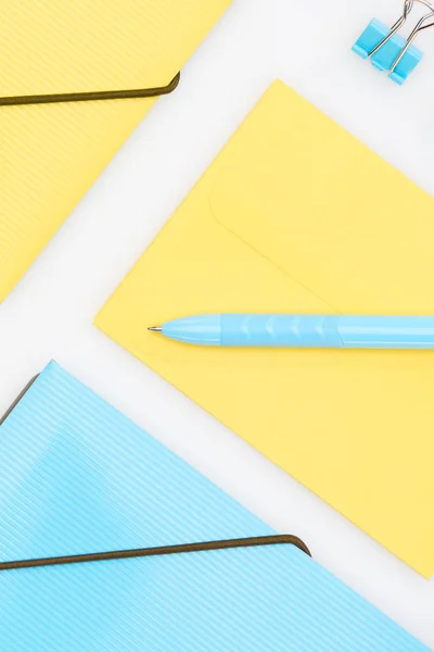 Gelbe und blaue Ordner, Briefumschlag Büroklammer und Stift isoliert auf weiß — Stockfoto