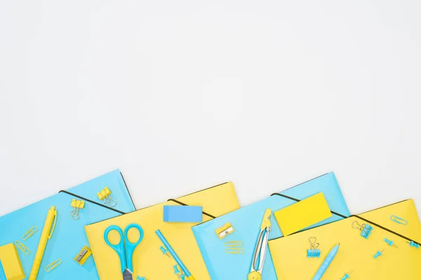 Vista superior de papelaria azul e amarelo isolado em branco — Fotografia de Stock