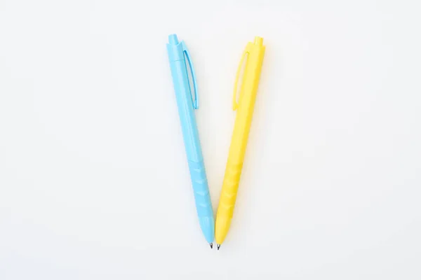 Вид зверху на жовті та сині схрещені олівці ізольовані на білому — стокове фото