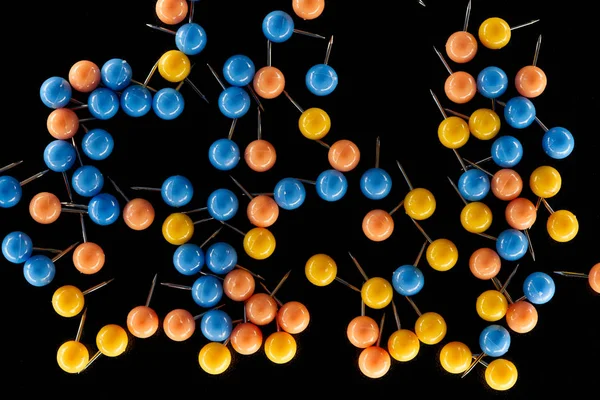 Top view of colorful paper clips with needles isolated on black — Stock Photo