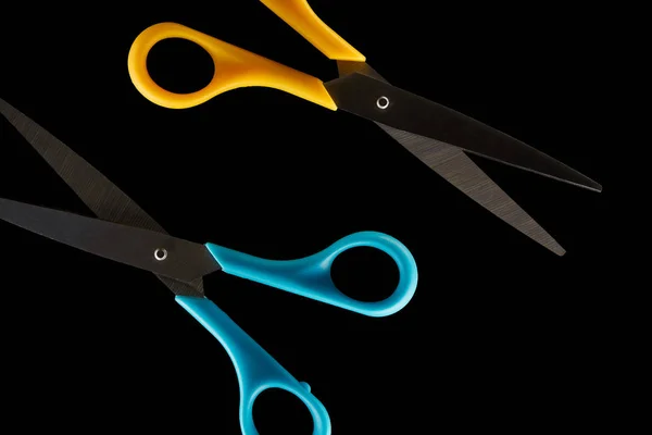 Top view of blue and yellow scissors isolated on black — Stock Photo