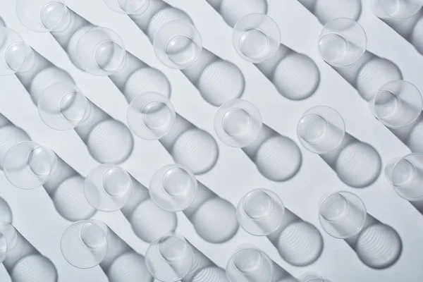 Vista superior de copos vazios descartáveis no fundo branco com sombras — Fotografia de Stock