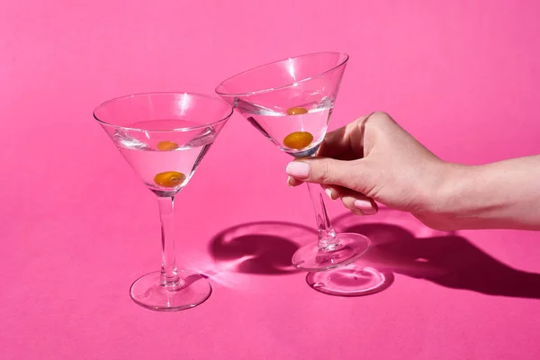 Cropped view of woman holding glass of cocktail on pink background — Stock Photo