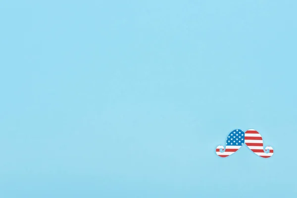 Top view of mustache made of american flag on blue background with copy space — Stock Photo