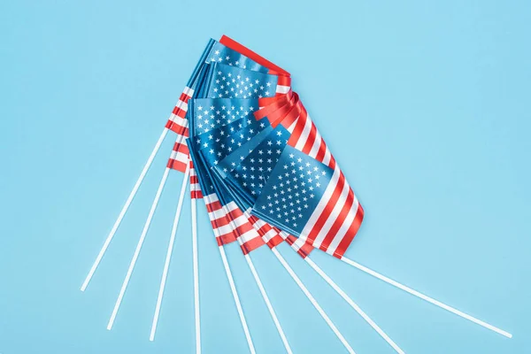 Top view of shiny american flags on sticks on blue background — Stock Photo