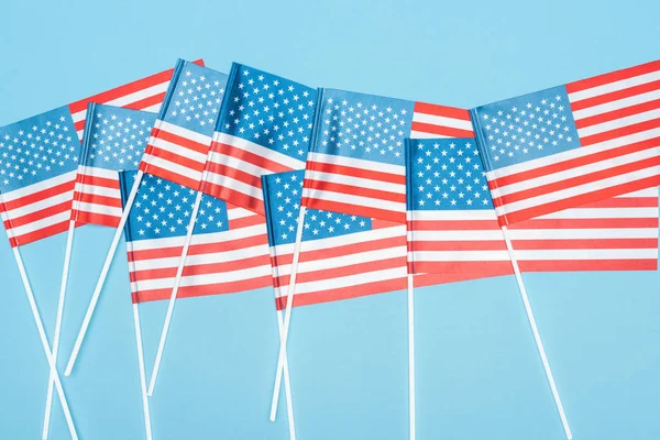 Vista superior das bandeiras dos EUA nacionais em paus no fundo azul — Fotografia de Stock