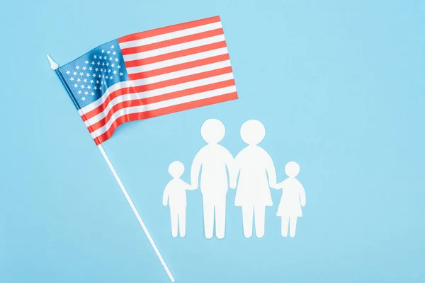 Вид зверху паперу вирізати сім'ю і американський прапор на синьому фоні — стокове фото