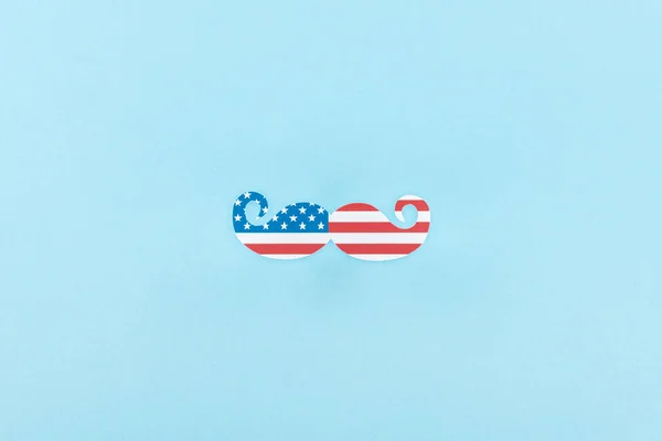 Vista superior de bigote decorativo hecho de bandera americana sobre fondo azul - foto de stock