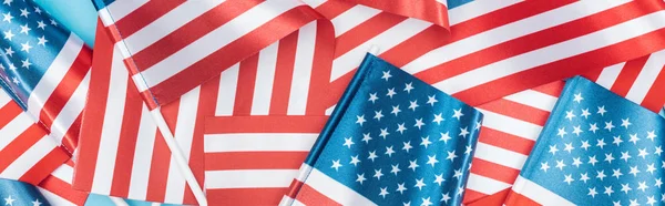 Panoramic shot of american flags stacked on blue background — Stock Photo