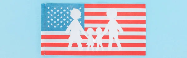 Panoramaaufnahme einer papiergeschnittenen weißen Familie auf amerikanischer Nationalflagge auf blauem Hintergrund — Stockfoto