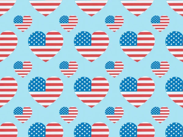 Senza soluzione di continuità modello di sfondo con cuori tagliati di carta fatta di bandiere americane su blu — Foto stock