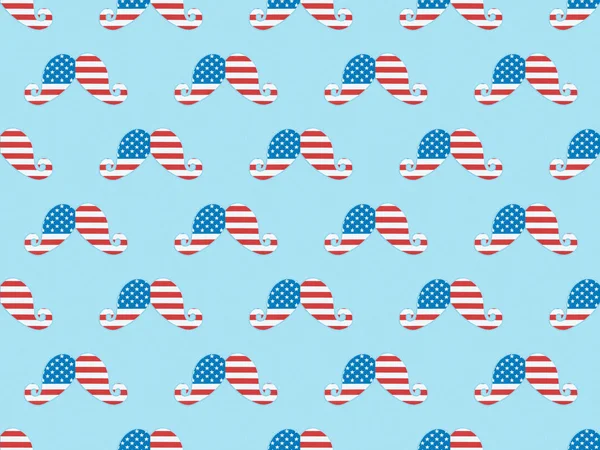 Seamless background pattern with paper cut mustache made of usa flags on blue — Stock Photo