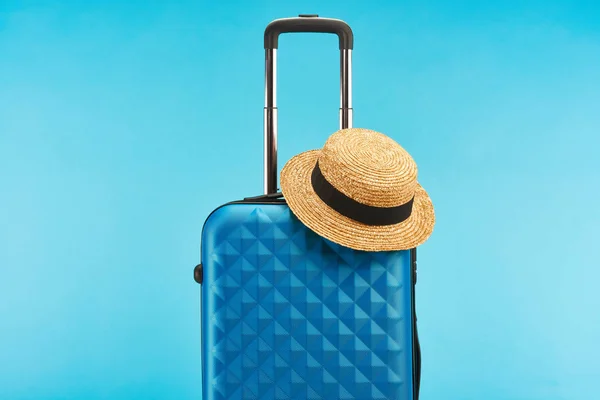 Saco de viagem colorido azul com alça e chapéu de palha isolado em azul — Fotografia de Stock