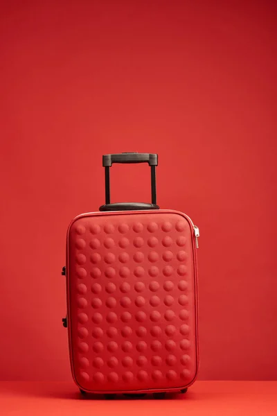 Rote bunt strukturierte Reisetasche isoliert auf rot — Stockfoto