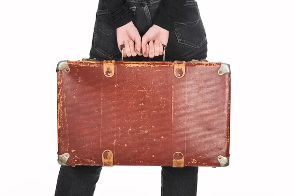 Vue partielle de la femme en jeans tenant une valise en cuir vintage isolée sur blanc — Photo de stock