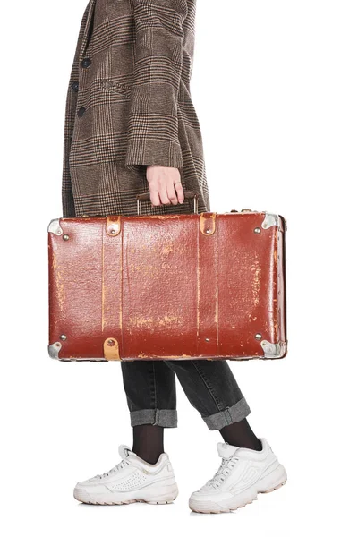 Cropped view of woman in plaid coat walking with vintage weathered suitcase isolated on white — Stock Photo