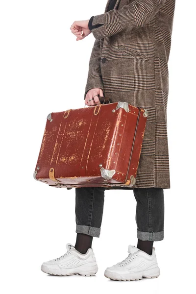 Обрезанный вид женщины в клетчатом пальто с винтажным выветриваемым чемоданом и время проверки изолированы на белом — стоковое фото