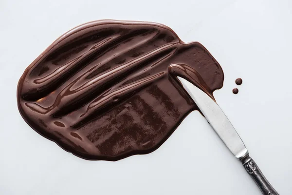 Vista superior del cuchillo de mesa con chocolate negro derretido - foto de stock