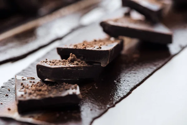 Foco seletivo de pedaços de chocolate com cacau em pó — Fotografia de Stock