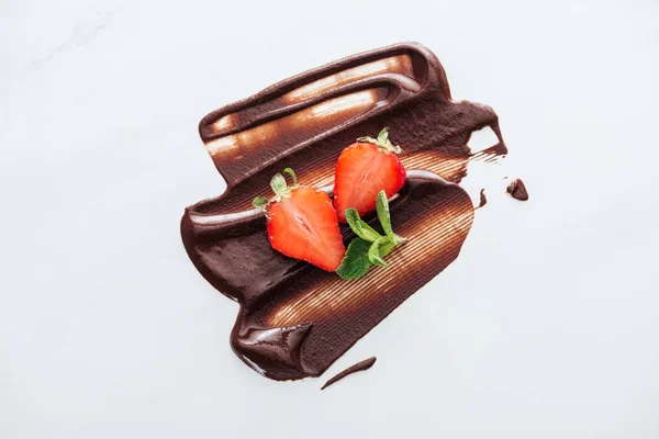 Top view of strawberries and fresh mint with liquid chocolate — Stock Photo