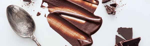 Панорамный снимок жидкого шоколада с кусочками шоколада и винтажной ложкой — стоковое фото