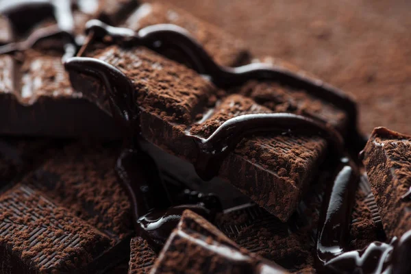 Vista da vicino di pezzi di barretta di cioccolato fondente con cioccolato liquido — Foto stock