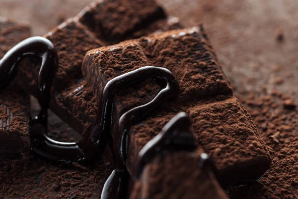 Selective focus of chocolate bar with melted chocolate and cocoa powder — Stock Photo