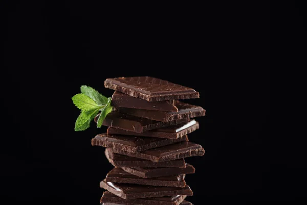 Pezzi scuri di cioccolato alla menta fresca, isolati su nero — Foto stock