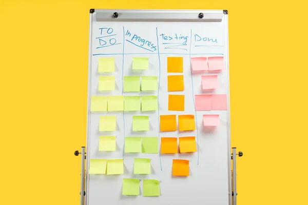 Pizarra de oficina blanca con notas adhesivas aisladas en amarillo - foto de stock