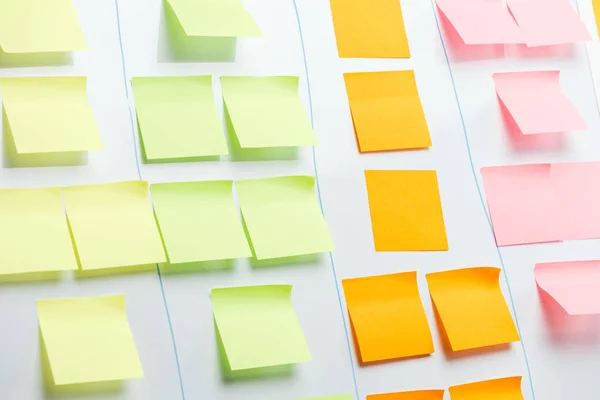 Tableau de bureau blanc avec des notes collantes colorées et l'espace de copie — Photo de stock